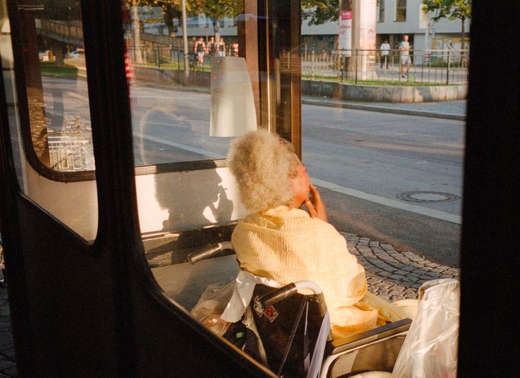 Femme âgée fumant une cigarette à un arrêt de bus